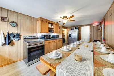 a kitchen with a long table with dishes on it at Group Getaway with Fire Pit Near Susquehanna River! in Danville