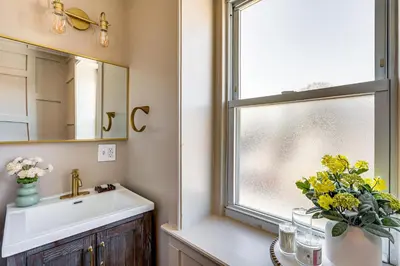 a bathroom with a sink and a window with yellow flowers at Walk to Public Transit Family Home in Mount Airy! in Philadelphia