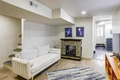 a living room with a white couch and a fireplace at Walk to Public Transit Family Home in Mount Airy! in Philadelphia