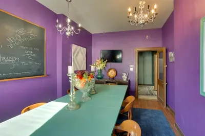 a dining room with purple walls and a table with flowers at Fun and Unique Home with Vintage Game Room in Annville in Annville