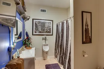a bathroom with a urinal and a sink and a toilet at Fun and Unique Home with Vintage Game Room in Annville in Annville