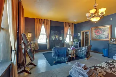 a bedroom with blue walls and a bed and chairs at Fun and Unique Home with Vintage Game Room in Annville in Annville