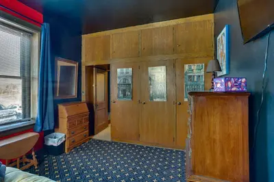 a room with a bedroom with blue walls and a wooden door at Fun and Unique Home with Vintage Game Room in Annville in Annville