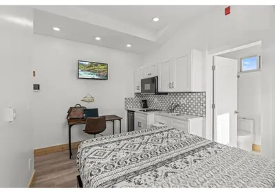 a white bedroom with a bed and a kitchen at Liberty bell GSN Harvest 1 in Philadelphia