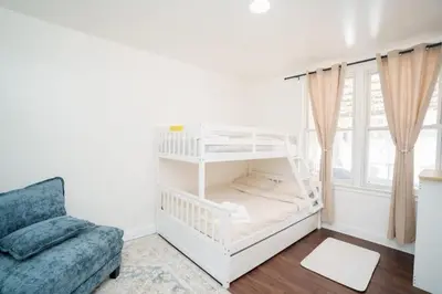 a white bunk bed in a room with a couch at Pet Friendly Jersey City Apartment Near NYC Sleeps 6 with Easy Manhattan Access in Jersey City