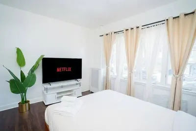 a white bedroom with a bed and a tv at Pet Friendly Jersey City Apartment Near NYC Sleeps 6 with Easy Manhattan Access in Jersey City