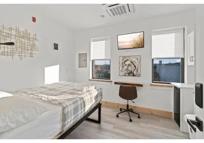 a bedroom with a bed and a desk and windows at Philadelphia Rocky steps GSN Harvest 2 in Philadelphia