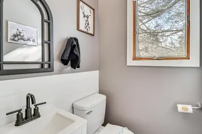 a bathroom with a toilet and a sink and a mirror at 1 Mi to Big Boulder Mountain Townhome with Grill in Lake Harmony