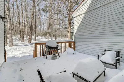 a snow covered porch with two chairs and a grill at 1 Mi to Big Boulder Mountain Townhome with Grill in Lake Harmony