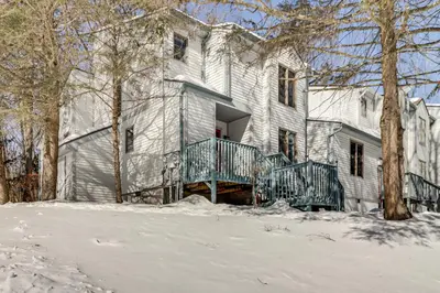 a large white house with a porch in the snow at 1 Mi to Big Boulder Mountain Townhome with Grill in Lake Harmony