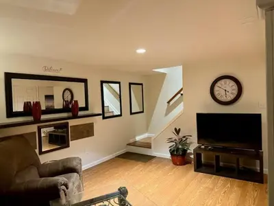 a living room with a tv and a clock on the wall at Huge house with Game Room, Hot Tub, 3 living rooms, 2 bonus rooms in Albrightsville