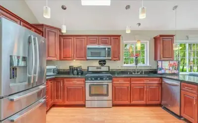a kitchen with wooden cabinets and stainless steel appliances at Huge house with Game Room, Hot Tub, 3 living rooms, 2 bonus rooms in Albrightsville