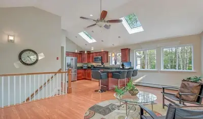 a kitchen and living room with a clock on the wall at Huge house with Game Room, Hot Tub, 3 living rooms, 2 bonus rooms in Albrightsville