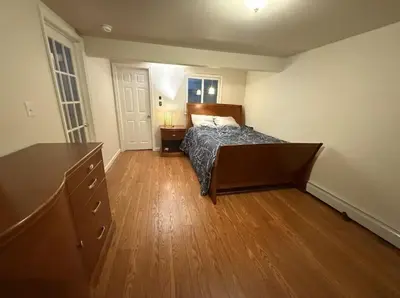 a bedroom with a bed and a wooden floor at Huge house with Game Room, Hot Tub, 3 living rooms, 2 bonus rooms in Albrightsville