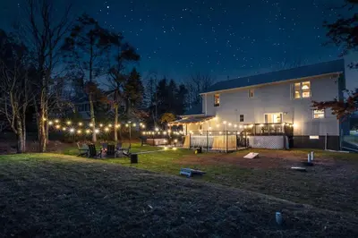 a house lit up at night with lights at Luxury Escape 5BR Pool HotTub Game Room FirePit in Long Pond