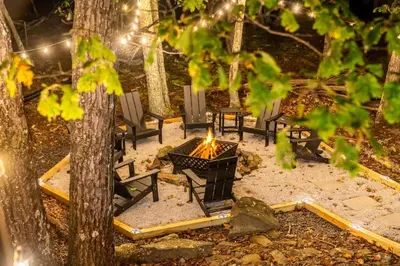 a group of chairs around a fire in the woods at Retreat HotTub FirePit Sauna GameRm Pool Playroom in East Stroudsburg