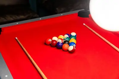 a red pool table with cue balls and sticks at Retreat HotTub FirePit Sauna GameRm Pool Playroom in East Stroudsburg