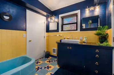 a blue and yellow bathroom with a tub and a sink at 10K sqft Estate 2 Pools Pond Games Sauna Hot Tub in East Stroudsburg