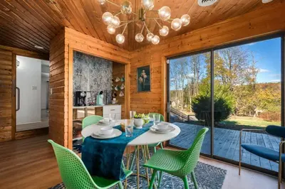 a dining room with a table and green chairs at 10K sqft Estate 2 Pools Pond Games Sauna Hot Tub in East Stroudsburg