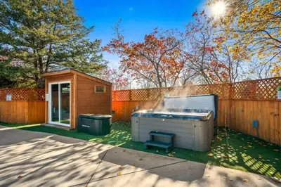 a hot tub in a yard next to a fence at 10K sqft Estate 2 Pools Pond Games Sauna Hot Tub in East Stroudsburg