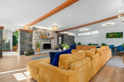 a living room with a large couch and a fireplace at 10K sqft Estate 2 Pools Pond Games Sauna Hot Tub in East Stroudsburg