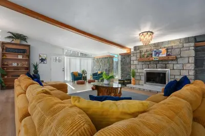 a living room with a large couch and a fireplace at 10K sqft Estate 2 Pools Pond Games Sauna Hot Tub in East Stroudsburg