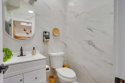 a white bathroom with a toilet and a mirror at Luxe Group Getaway 6 Mi to Manhattan! in Jersey City