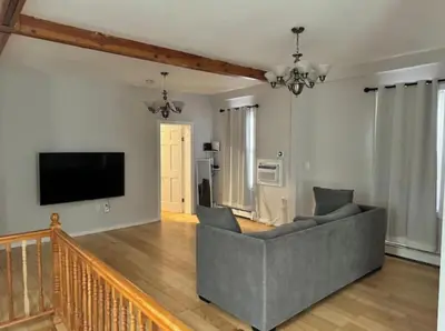 a living room with a couch and a flat screen tv at Americana in Jersey City