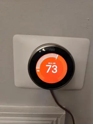 an orange and black clock on a wall at Americana in Jersey City