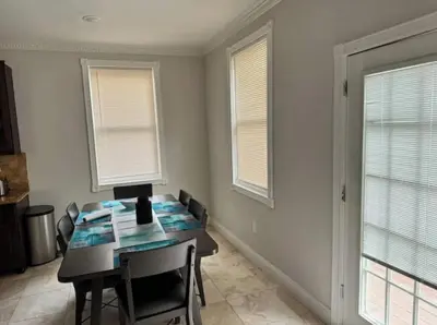 a dining room with a table and two windows at Americana in Jersey City