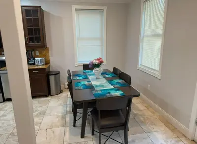a dining room table with chairs and a vase of flowers on it at Americana in Jersey City