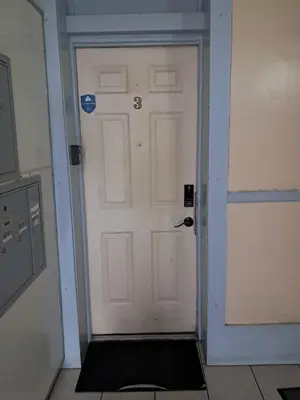 a white door with a black door mat in front of it at Casa Yael in West New York