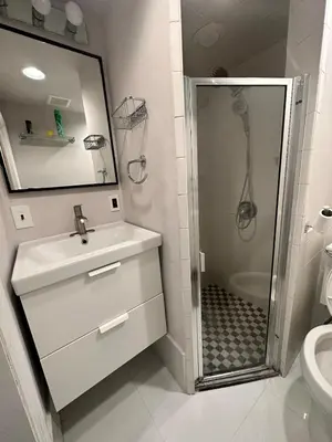 a white bathroom with a sink and a shower at Casa Yael in West New York