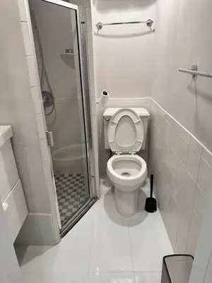 a small bathroom with a toilet and a shower at Casa Yael in West New York