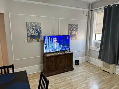 a living room with a flat screen tv on a cabinet at Casa Yael in West New York