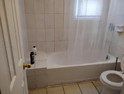 a bathroom with a tub and a toilet at Grove#1 in Irvington