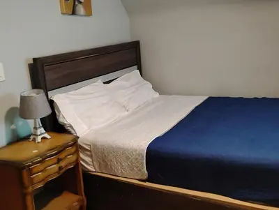 a bedroom with a bed and a night stand with a lamp at Grove#1 in Irvington