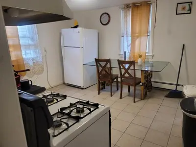 a kitchen with a white refrigerator and a table with chairs at Grove#1 in Irvington