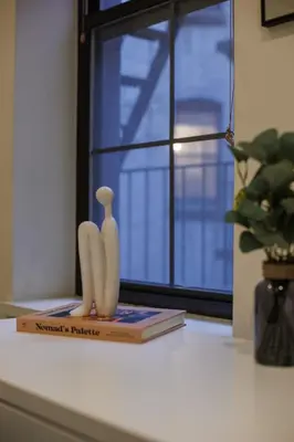 a book and two banana figurines on a window sill at Refined & Stylish Manhattan Haven in New York