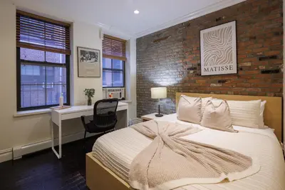 a bedroom with a bed and a brick wall at Refined & Stylish Manhattan Haven in New York