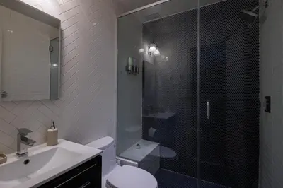 a bathroom with a shower and a toilet and a sink at Refined & Stylish Manhattan Haven in New York