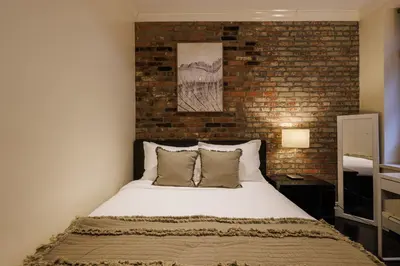 a bedroom with a bed with a brick wall at Refined & Stylish Manhattan Haven in New York