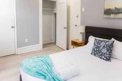a bedroom with a white bed with a blue blanket on it at Spacious 3 bedrooms Apartment-20 mins to NYC in West New York