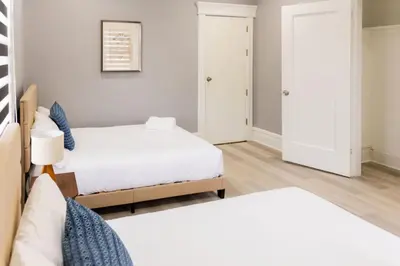 a bedroom with two beds and two doors at Spacious 3 bedrooms Apartment-20 mins to NYC in West New York
