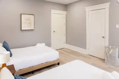 a bedroom with two beds and a table at Spacious 3 bedrooms Apartment-20 mins to NYC in West New York