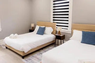 two beds sitting next to each other in a bedroom at Spacious 3 bedrooms Apartment-20 mins to NYC in West New York