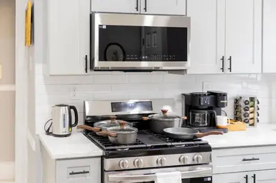 a kitchen with a stove with pots and pans at Spacious 3 bedrooms Apartment-20 mins to NYC in West New York