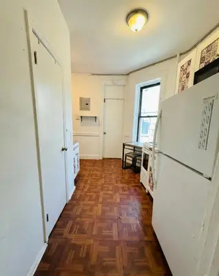 a hallway with a white refrigerator and a wooden floor at Upper West Side Apartment 10 minutes walk From Central Park in New York