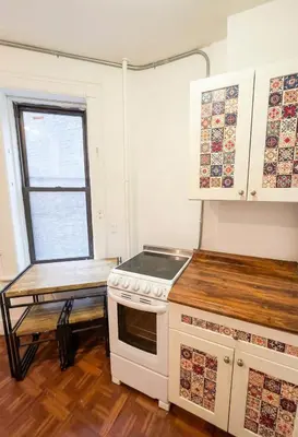 a kitchen with a stove and a table in it at Upper West Side Apartment 10 minutes walk From Central Park in New York