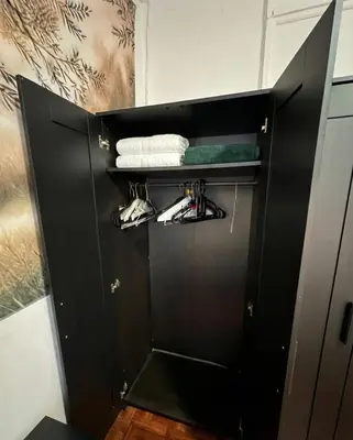 a black cabinet with shoes and towels in a bathroom at Upper West Side Apartment 10 minutes walk From Central Park in New York